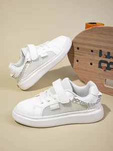 Κοντινή λήψη λευκών αναπνεύσιμων sneakers με πλέγμα για κορίτσια με ασημένια αλυσίδα