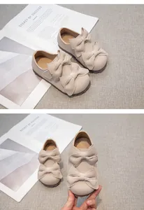 Detailansicht von beigen Mädchen-Prinzessin-Schuhen mit eleganter doppelter Schleife.