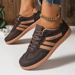 Close-up of brown casual GAT sneakers featuring tan stripes and WALKING text print