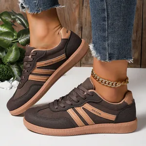 Close-up of women's brown lightweight German trainer shoes worn with denim jeans.