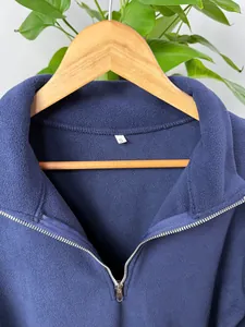 Close-up detail of navy blue fleece pullover featuring silver half-zip stand-up collar