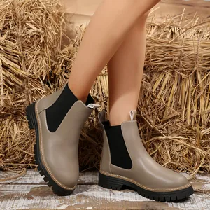 Vista detallada de botines Chelsea para mujer color topo con suelas gruesas en exteriores.