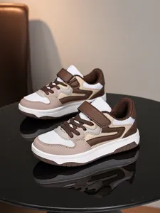Vue latérale de baskets décontractées marron et beige pour enfants sur table