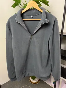 A high-quality detailed view of a grey men's half-zip fleece sweatshirt with a stand collar.