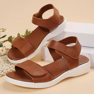 Detail of brown faux leather platform sandals with adjustable velcro straps for women.