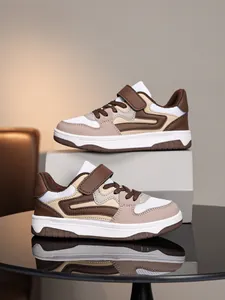 Détail en gros plan de baskets décontractées marron et beige pour enfants sur miroir