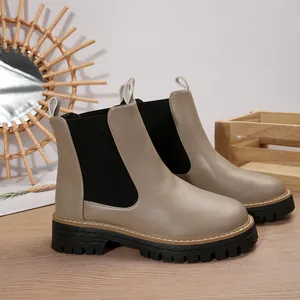 Vista detallada de botines Chelsea beige para mujer con suela track gruesa de color negro.