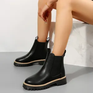 Vista detallada de botines Chelsea negros de estilo británico con suela gruesa
