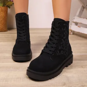 Primer plano de botas Martin negras con tacón grueso y un elegante estampado de leopardo lateral