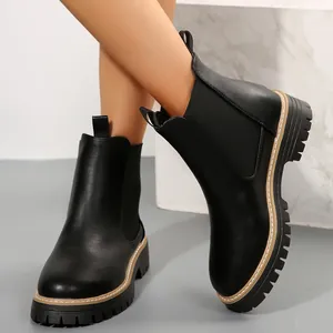 Detalle de elegantes botines Chelsea negros con plataforma y suela de goma texturizada