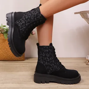 Primer plano de botas militares negras con estampado de leopardo y suela gruesa