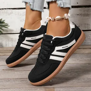 Close-up of black and white women's German trainer shoes with gum soles and lace-up design