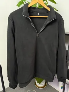 Men's solid color polar fleece quarter-zip pullover sweatshirt shown on a wooden hanger