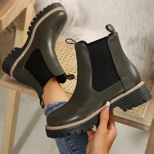 Primer plano de botines Chelsea verde oliva con suela de plataforma y paneles elásticos