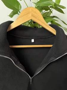 Close-up detail of a men's black fleece quarter-zip pullover with a metallic zipper