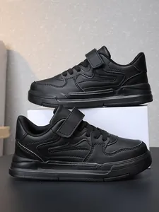Gros plan de baskets de sport noires pour enfants avec une sangle velcro résistante