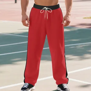 Detail of men's red sweatpants with black side stripes and white adjustable drawstrings.