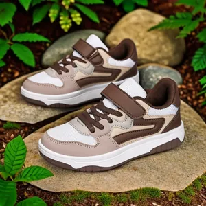 Baskets pour enfants en blocs de couleurs marron et beige sur des rochers naturels