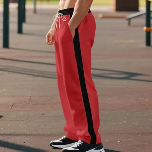 Side view of red heavy French terry sweatpants with black side stripe and drawstring