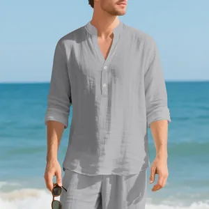 Graues Leinen-Henley-Shirt für Herren mit Knöpfen und Stehkragen am Strand