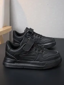 Gros plan de baskets noires pour enfants avec fermeture à scratch pour l'école