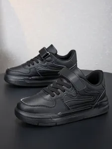 Vue latérale de chaussures de sport décontractées noires pour enfants avec velcro