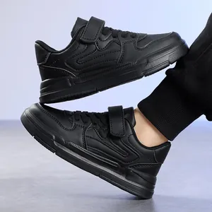 Détail latéral de baskets noires pour garçons avec Velcro et semelle antidérapante