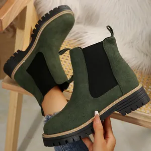 Detalle de botines Chelsea de ante verde con suela de plataforma y paneles elásticos