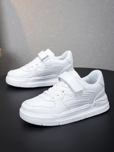 Détail de profil latéral de baskets blanches pour enfants avec bride velcro.