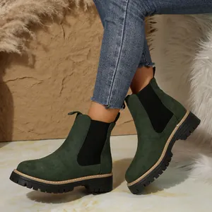 Botines Chelsea de ante verde oscuro para mujer con suela gruesa, mostrados con vaqueros.