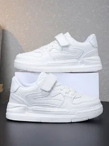 Vue latérale détaillée de baskets de sport blanches classiques pour enfants avec scratch