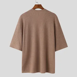 Close-up back view of a brown ribbed knit mid-sleeve shirt in a relaxed loose fit style.