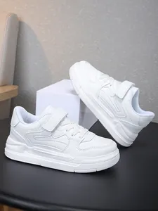 Vue détaillée de baskets de sport blanches pour enfants avec fermeture à scratch et lacets