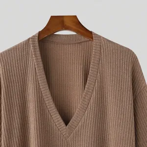 Detailed view of the V-neckline and soft ribbed texture on a brown knitted top