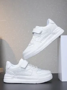Vue latérale de baskets blanches pour enfants avec fermetures à scratch et coutures ondulées
