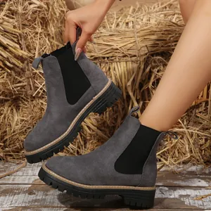 Primer plano de elegantes botines Chelsea grises con suelas gruesas y paneles elásticos