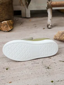 Detailed view showing the white textured non-slip rubber sole of olive women's loafers.