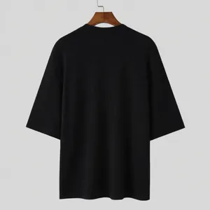 Detailed back view of a black ribbed knit half-sleeved T-shirt featuring a casual loose fit.