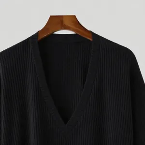 Close-up showing the premium black ribbed knit texture and deep V-neckline of the shirt.