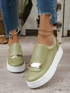 Close-up detail of olive green platform loafers featuring elegant gold buckle decoration