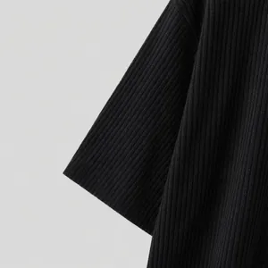Detailed close-up of premium black ribbed knit fabric showing texture and sleeve cuff