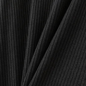 Close-up of black ribbed knit fabric showing detailed texture and vertical stripes