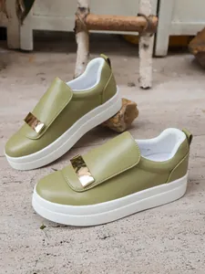 Detailed close-up of trendy olive green platform loafers with metallic gold buckle accent