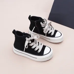 Vue détaillée de baskets montantes en toile pour enfants avec lacets épais et semelles compensées.