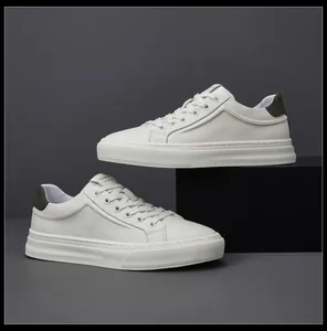 Vue détaillée de baskets minimalistes en cuir blanc pour hommes sur fond gris élégant