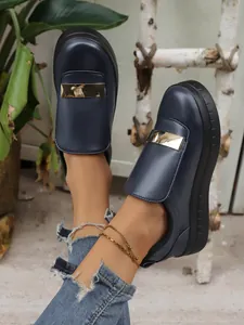 Detailed macro view of dark blue platform loafers with elegant golden metal buckle