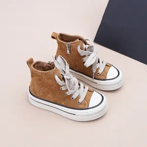 Détail de baskets montantes marron pour enfants avec fermeture éclair et semelle blanche