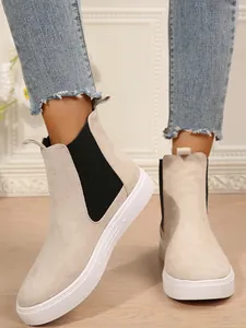 Detalle de los elegantes botines Chelsea beige para mujer con suela de plataforma blanca
