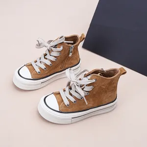 Vue détaillée de baskets montantes pour enfants en daim marron avec zip et semelle blanche.