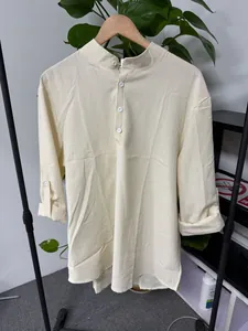 Detail view of men's pale yellow mandarin collar shirt with subtle grid texture